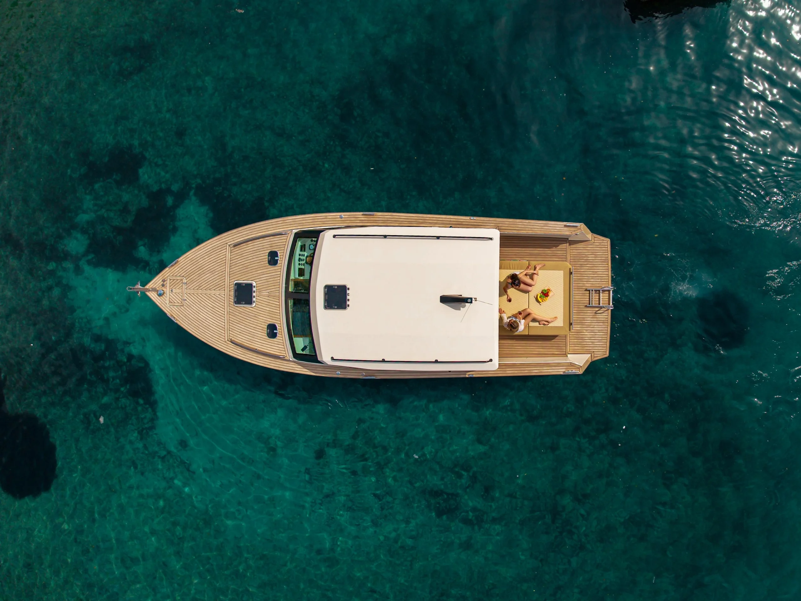 Widok z lotu ptaka na luksusową prywatną łódź Aliskaf 37 z gośćmi relaksującymi się na pokładzie w krystalicznie czystych wodach Adriatyku w pobliżu Hvaru.