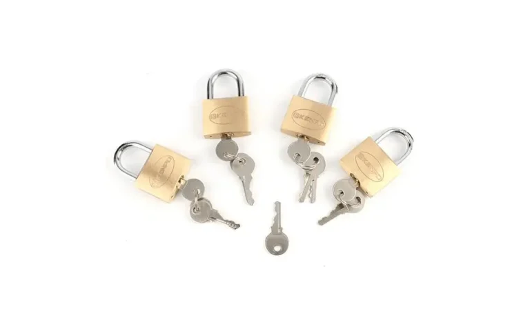 Zestaw mosiężnych kłódek z pasującymi kluczami ułożonymi na białym tle