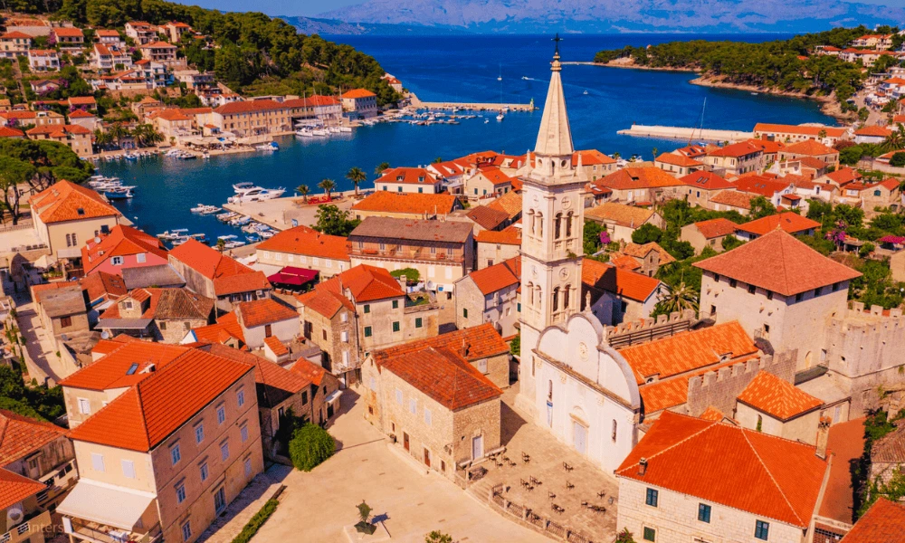 Widok z lotu ptaka na Jelsę na wyspie Hvar z wieżą kościoła, portem, kamiennymi domami i turkusową zatoką