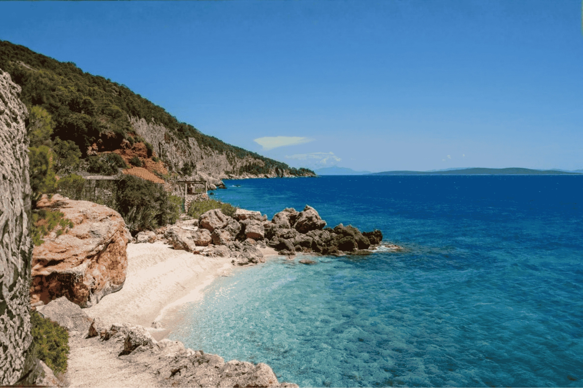 Rocky coastline and crystal-clear turquoise sea in Sveta Nedjelja on Hvar Island, with cliffs and a small secluded beach.