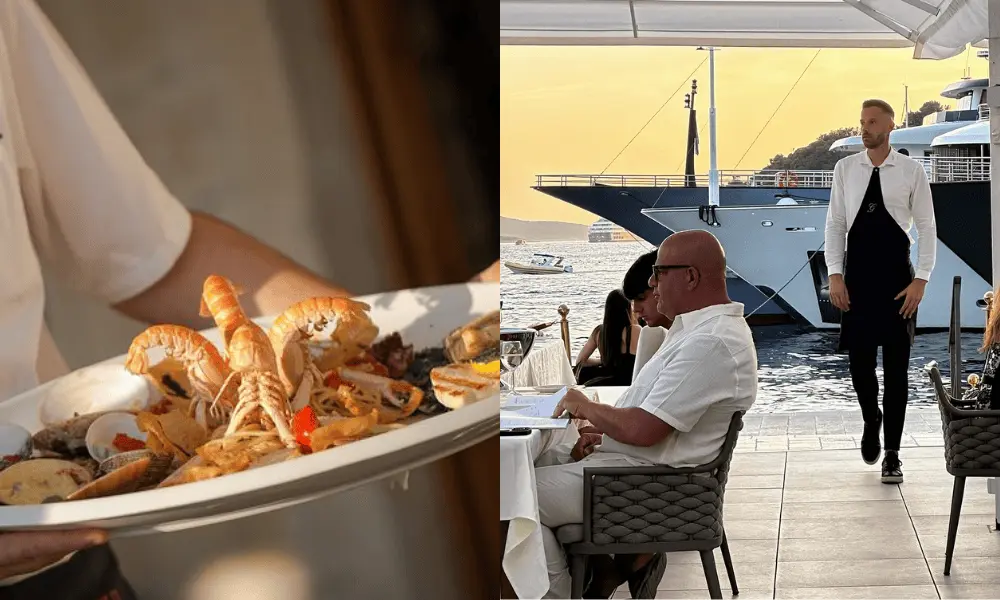 Podawane owoce morza i goście jedzący w eleganckiej restauracji nad brzegiem morza w Hvarze, w tle widać jachty.