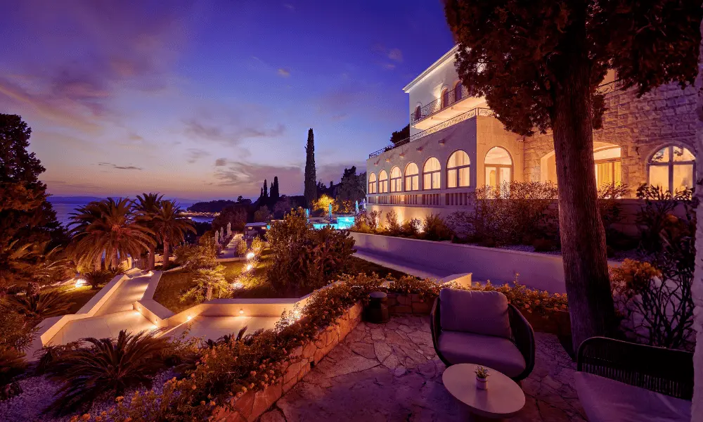 Zachód słońca nad hotelem Moëses Heritage w Hvarze, otoczonym śródziemnomorskimi ogrodami i z widokiem na Morze Adriatyckie.
