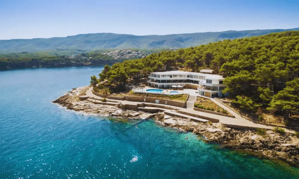 Widok z lotu ptaka na hotel położony nad morzem w miejscowości Jelsa na wyspie Hvar, otoczony lasem sosnowym i krystalicznie czystymi wodami Adriatyku.