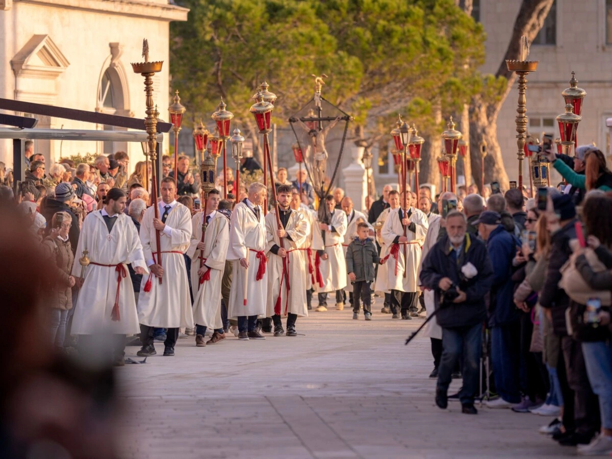 Traditional “Za Križen” procession on Hvar, with participants in white robes carrying lanterns and crosses, surrounded by crowds of onlookers